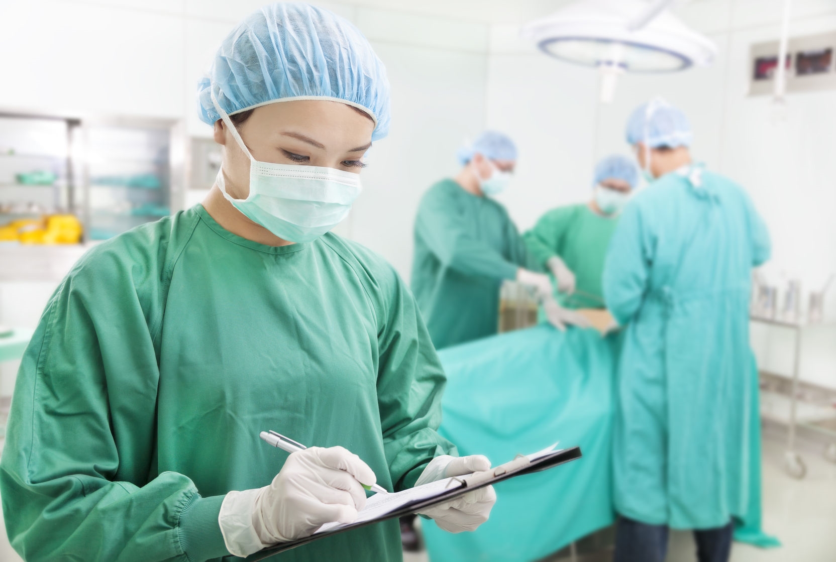 25791332 - asian woman surgeons writing records on form